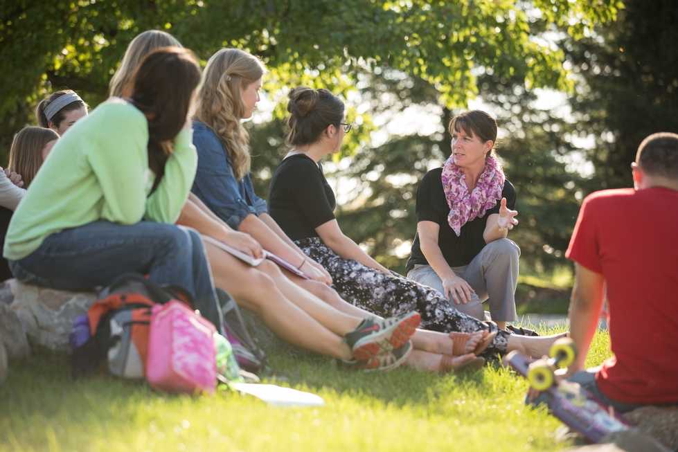 faculty member teaching a class outside on the lawn